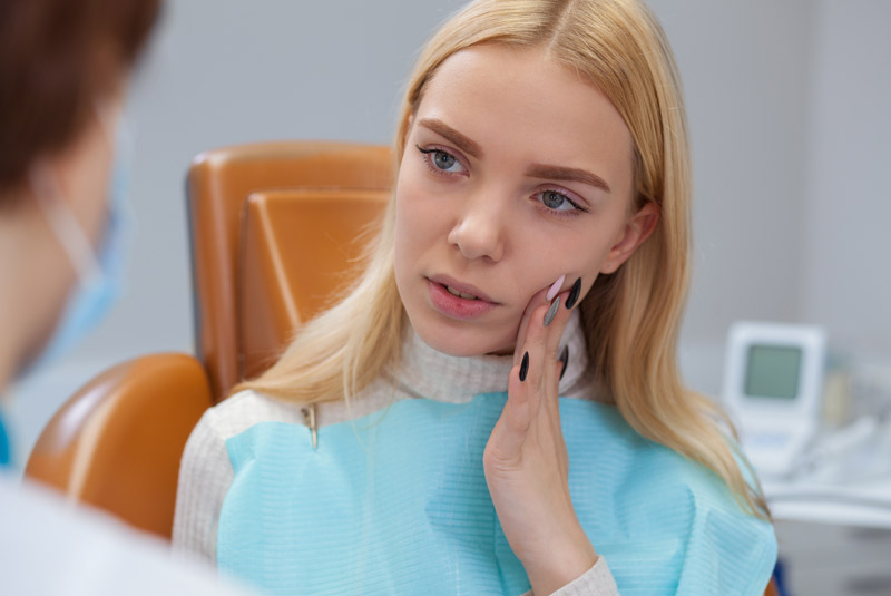 Nice girl holding her mouth in pain