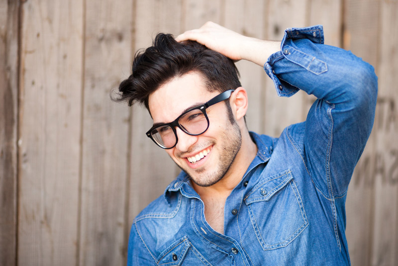 Nice guy smiling with dark hair because he took care of his dental problems