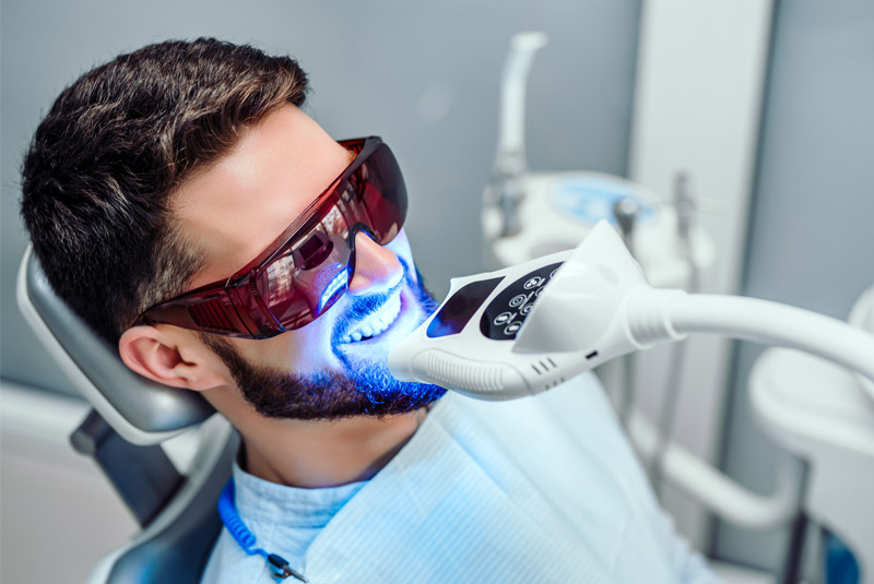 Guy with dark hair getting his teeth whitened