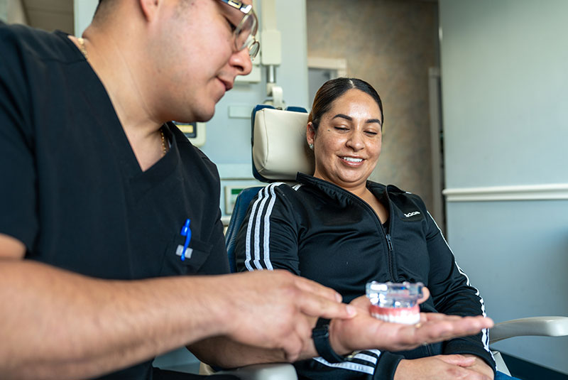 doctor and patient looking over dental implant model