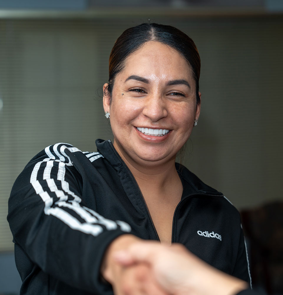patient shaking hands with staff member at the front desk